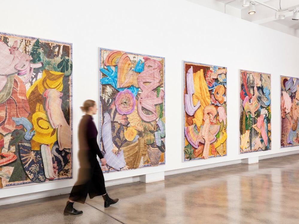 A woman walking through an art gallery and seeking to exhibit her art work. Custom D's  global Fintech platform - AWS Art Money is perfect for her.